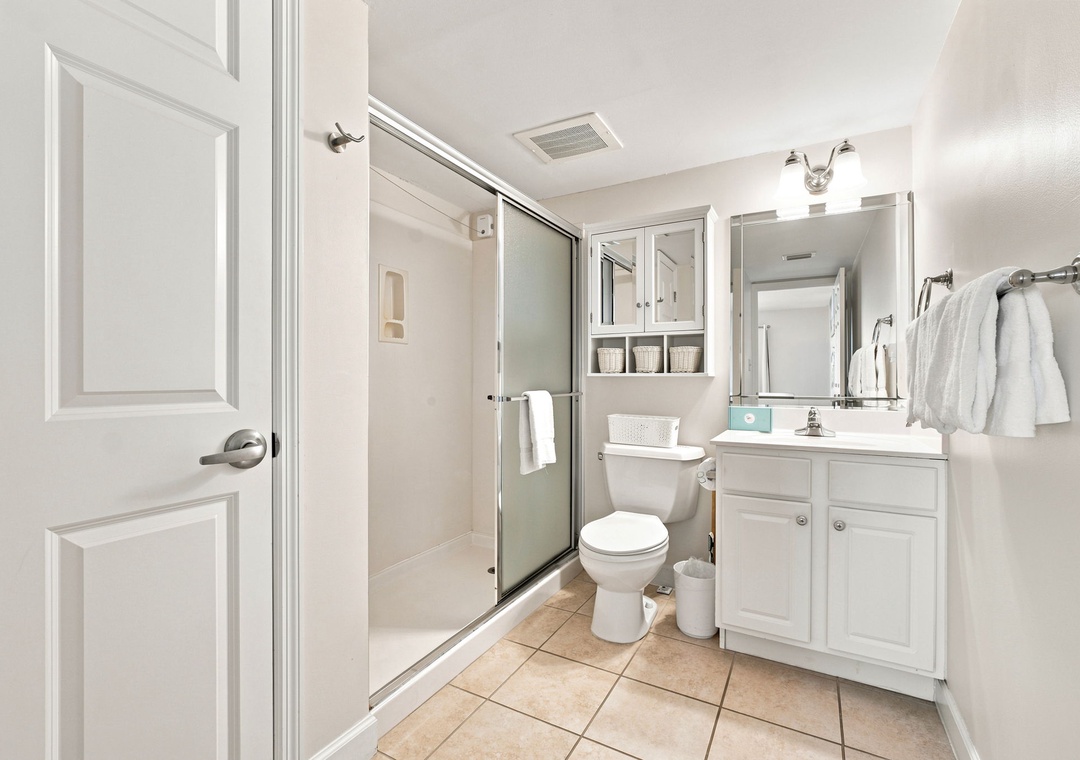 Sandy Key 411- Step into your bright, modern bathroom with crisp white cabinetry, a spacious walk-in shower, and everything you need to refresh after a day of adventure.