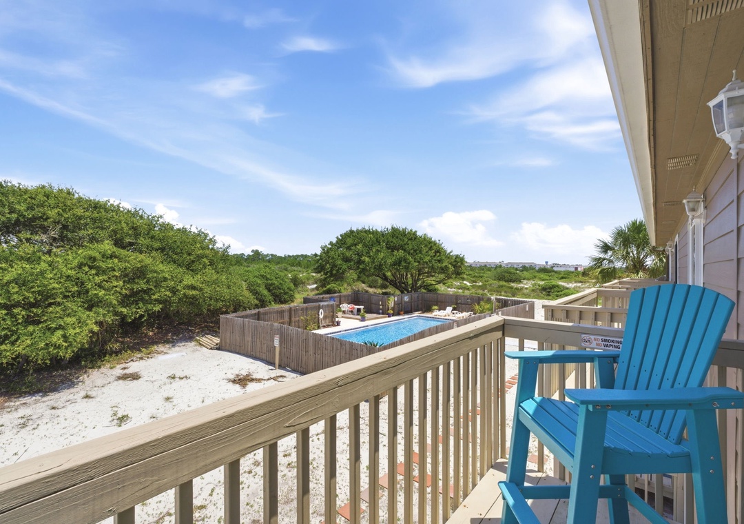 North Lost Key Landing B2- Balcony overlooking coastal greenery, swimming pool, and beach surroundings. Private outdoor seating invites relaxation with scenic views and coastal breezes.
