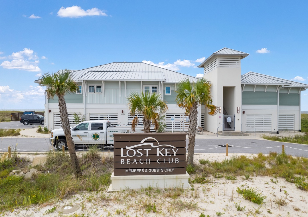 The Lost Key Beach Club welcomes members and guests with its coastal architecture, palm-lined entrance, and convenient parking, situated in a natural beachside setting.