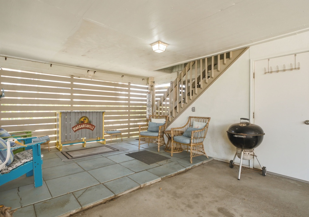 Cozy patio with rattan seating and BBQ grill, perfect for outdoor gatherings and grilling your favorite meals during your stay.