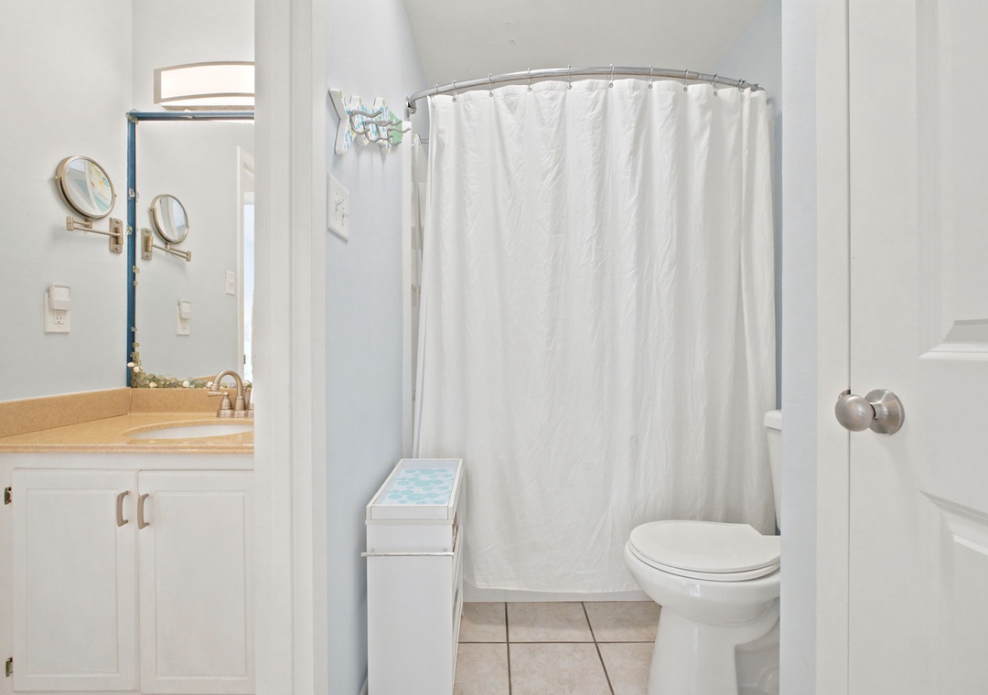 You'll appreciate the bright, clean bathroom with its curved shower, generous counter space, and thoughtful details like the magnifying mirror for your morning routine.