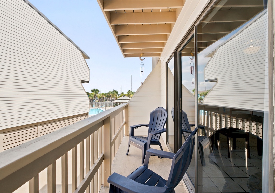 Relax in your own Adirondack chairs, catching glimpses of the pool through the palms. A gentle breeze, soft chimes, and a pergola overhead make this your perfect escape.