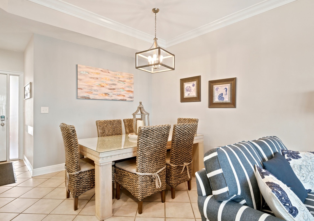 SeaChase 1104C- Gather around this inviting dining table where your group can share meals and make memories. Coastal artwork and woven chairs create a relaxed, beachy atmosphere for your vacation.