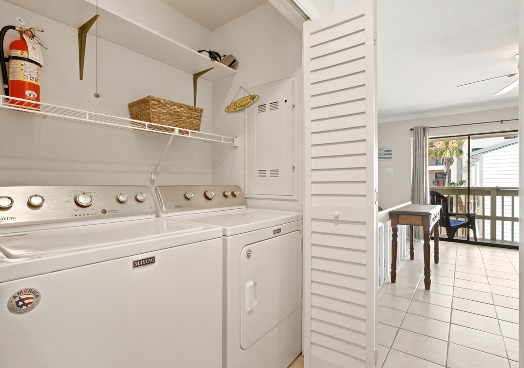 Your vacation stays effortless with in-unit laundry facilities, featuring a washer and dryer alongside convenient shelving for all your essentials and beach gear.