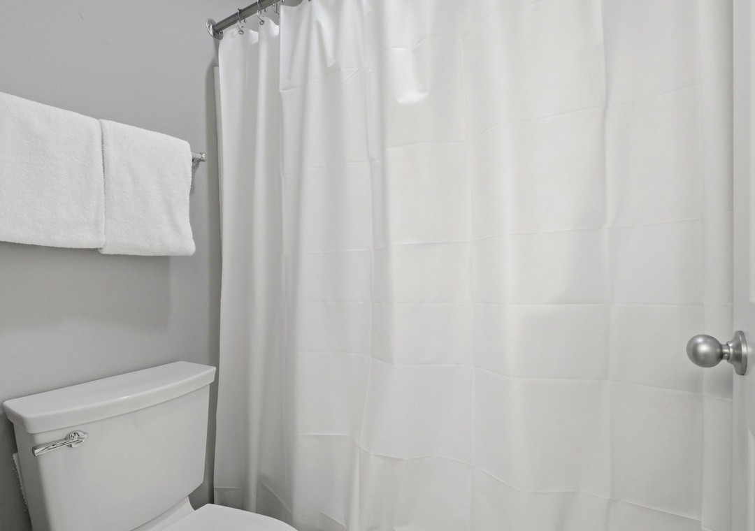 Lighthouse 418- Your private bathroom features a clean, modern design with a tiled shower and fresh towels ready for your arrival.