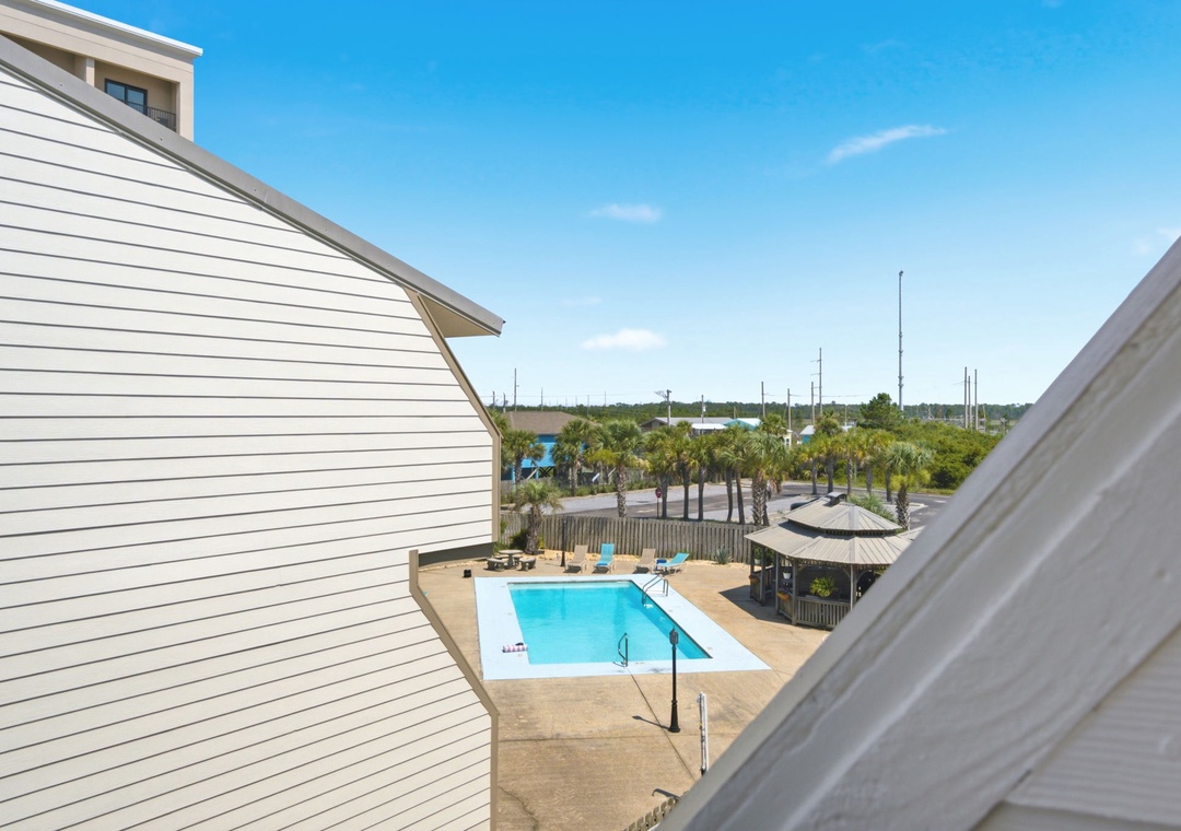 Your balcony offers a bright view of the sparkling pool, lush palms, and coastal scenery—perfect for morning coffee or sunset drinks.