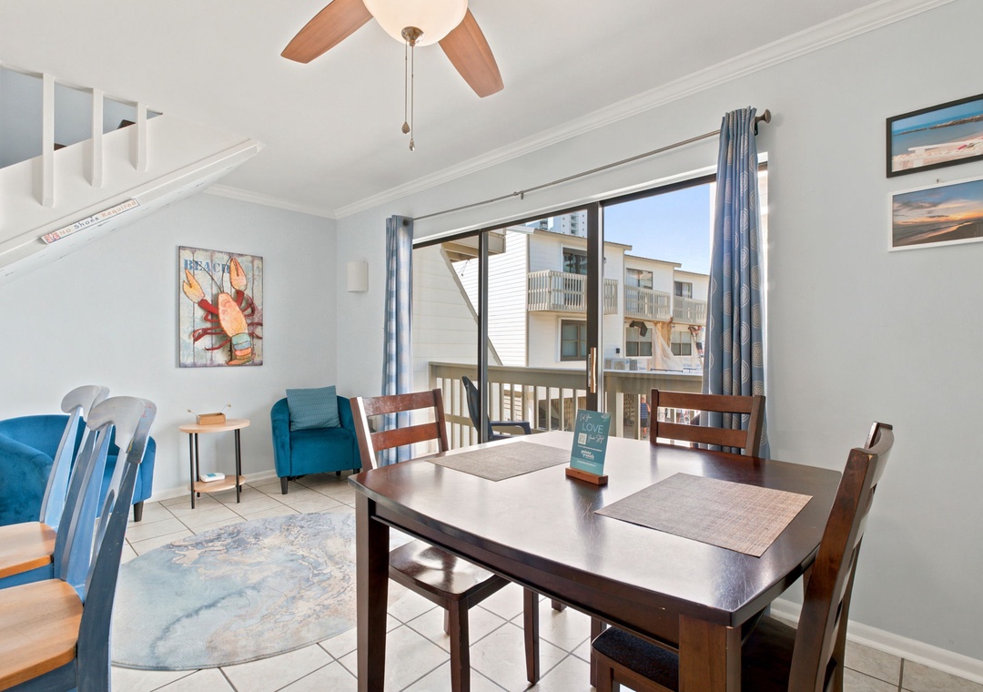 Step into your bright dining area with coastal charm, where meals feel easy and breezy. The table seats your group comfortably, and beyond the sliding doors, your private balcony awaits with ocean-inspired views.