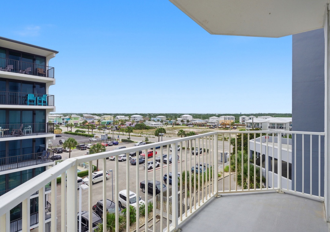 Elevated vantage point capturing the surrounding suburban landscape with residential buildings, parking areas, and developing neighborhood infrastructure under a clear sky.