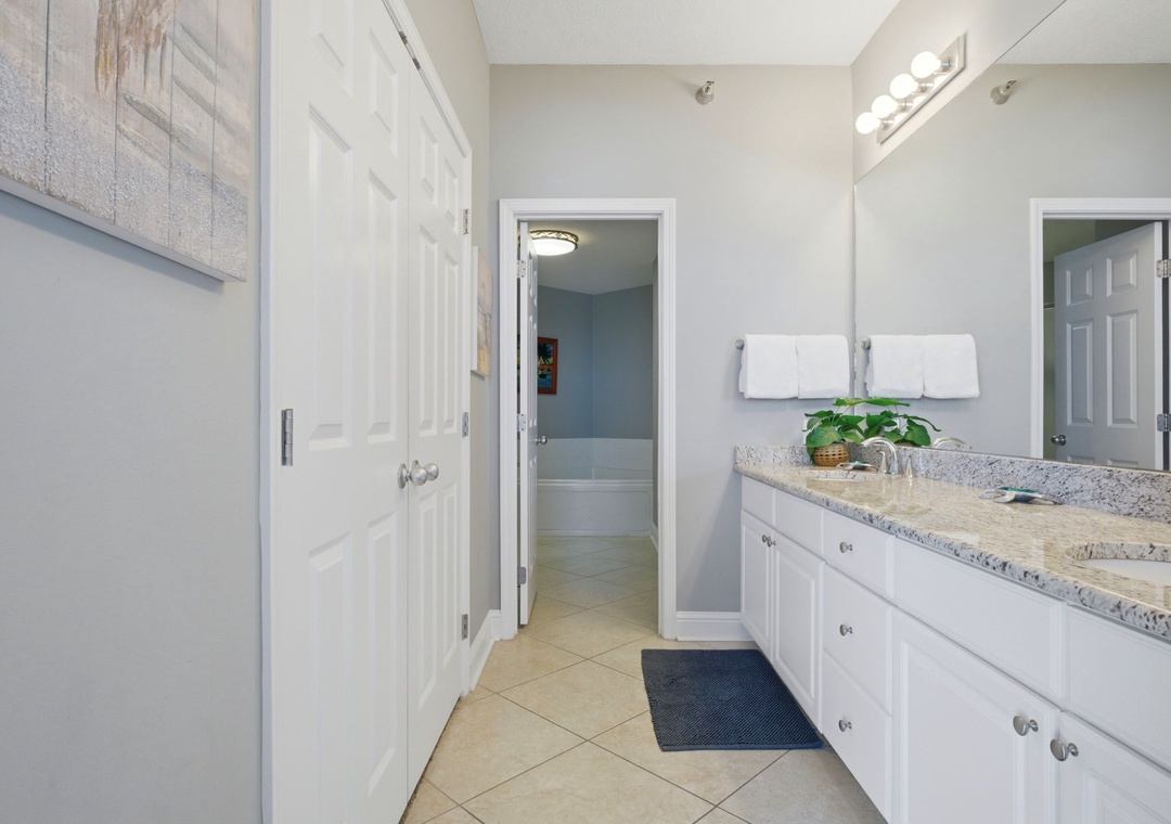 Lighthouse 418- Step into your bright, spacious bathroom featuring granite countertops, crisp white cabinetry, and thoughtful touches like fluffy towels and fresh greenery. Everything you need for a refreshing start to your day.