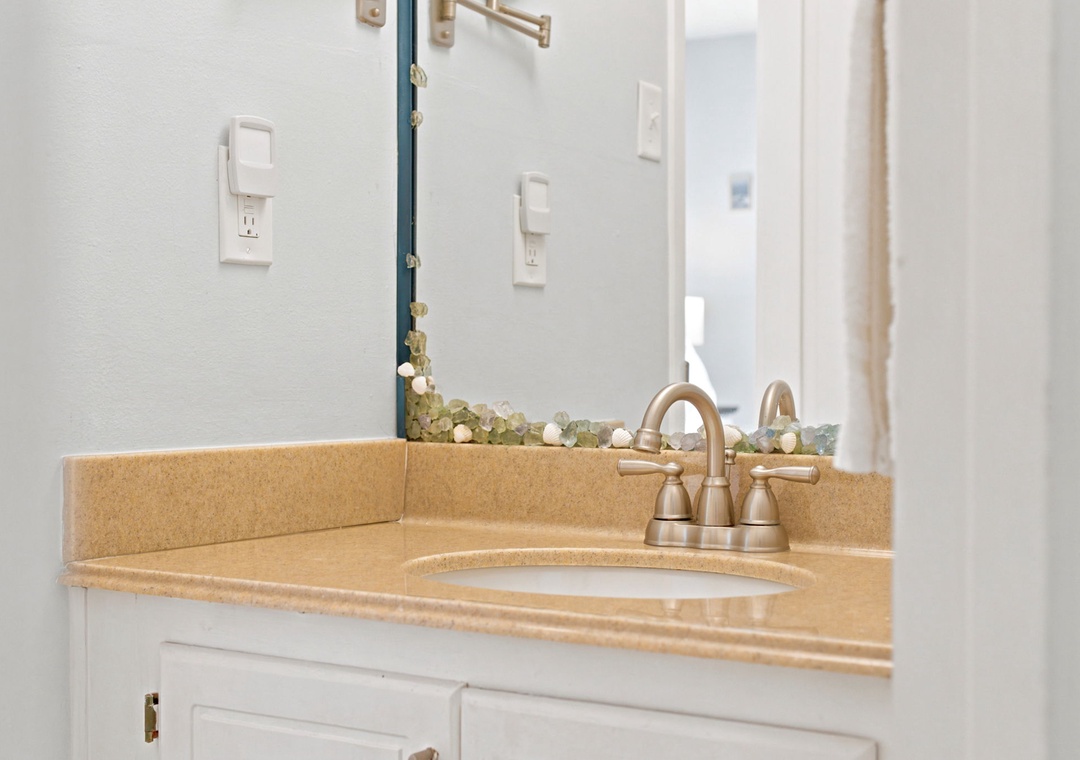 Step into your private bathroom with fresh, clean finishes and thoughtful touches, where the warm countertop and brushed fixtures create an inviting space for your daily routine.