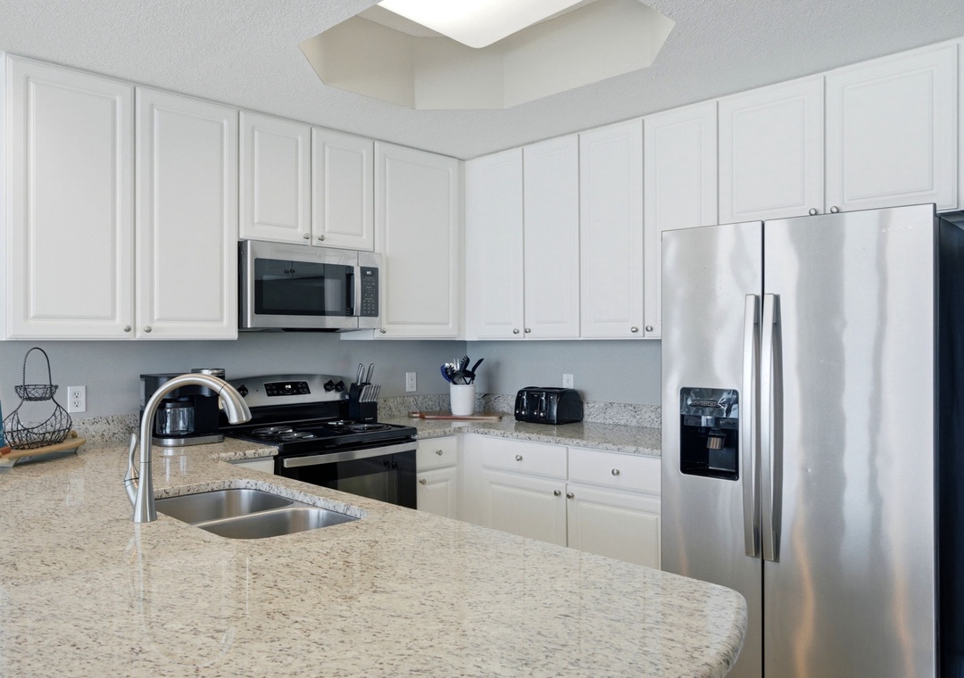 Lighthouse 418- Bright and spacious kitchen equipped with modern appliances, granite countertops, and all the essentials for preparing your favorite home-cooked meals during your stay.