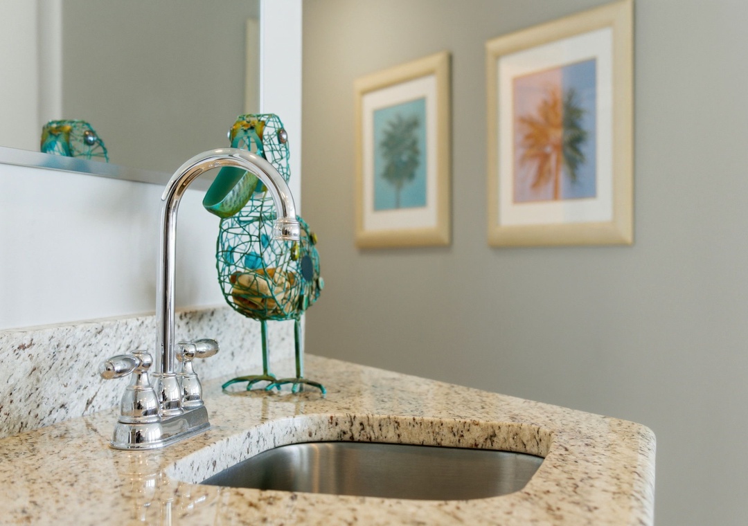 Lighthouse 418- Picture yourself freshening up at this stylish granite vanity with its gleaming faucet and playful coastal décor—your perfect start to a relaxing getaway morning.