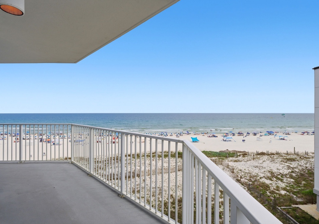 Expansive beachfront balcony offering unobstructed views of the sandy shore and sparkling ocean, perfect for morning coffee or sunset watching in complete coastal serenity.