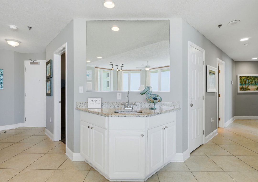 Lighthouse 418- Step inside to find a welcoming vanity area featuring elegant granite countertops and coastal-inspired decor, setting the tone for your relaxing beachside retreat.