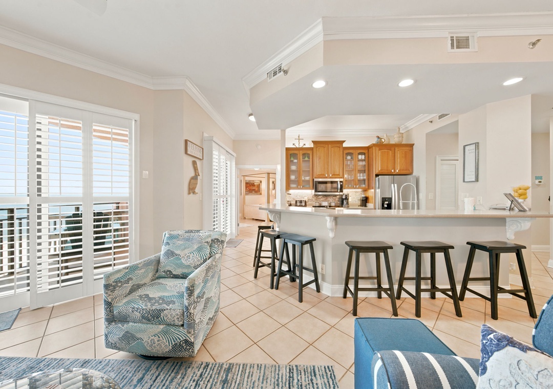 SeaChase 1104C-Relax in your open-concept living space, where coastal blue seating flows into a bright kitchen with breakfast bar—perfect for morning coffee or casual meals together.