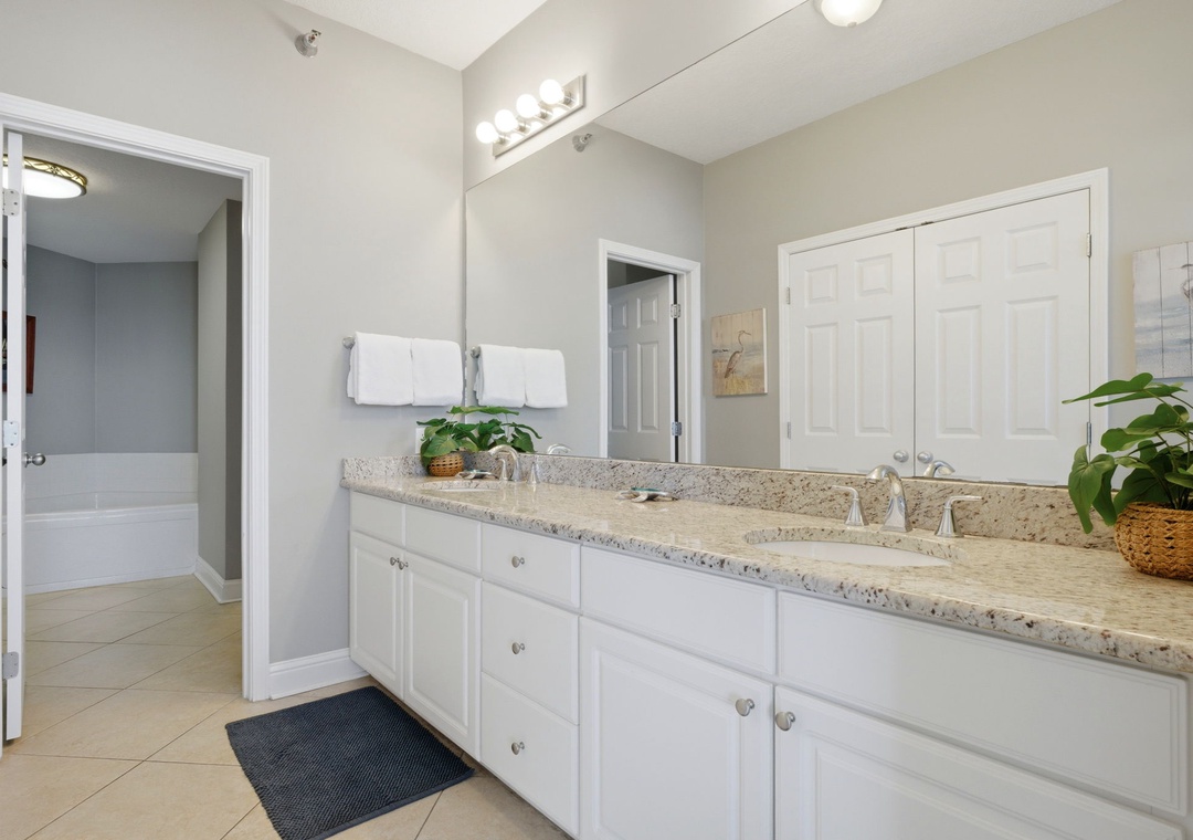 Lighthouse 418- Step into your spacious bathroom with dual sinks, elegant granite countertops, and bright vanity lighting. Fresh towels and thoughtful touches await your arrival.