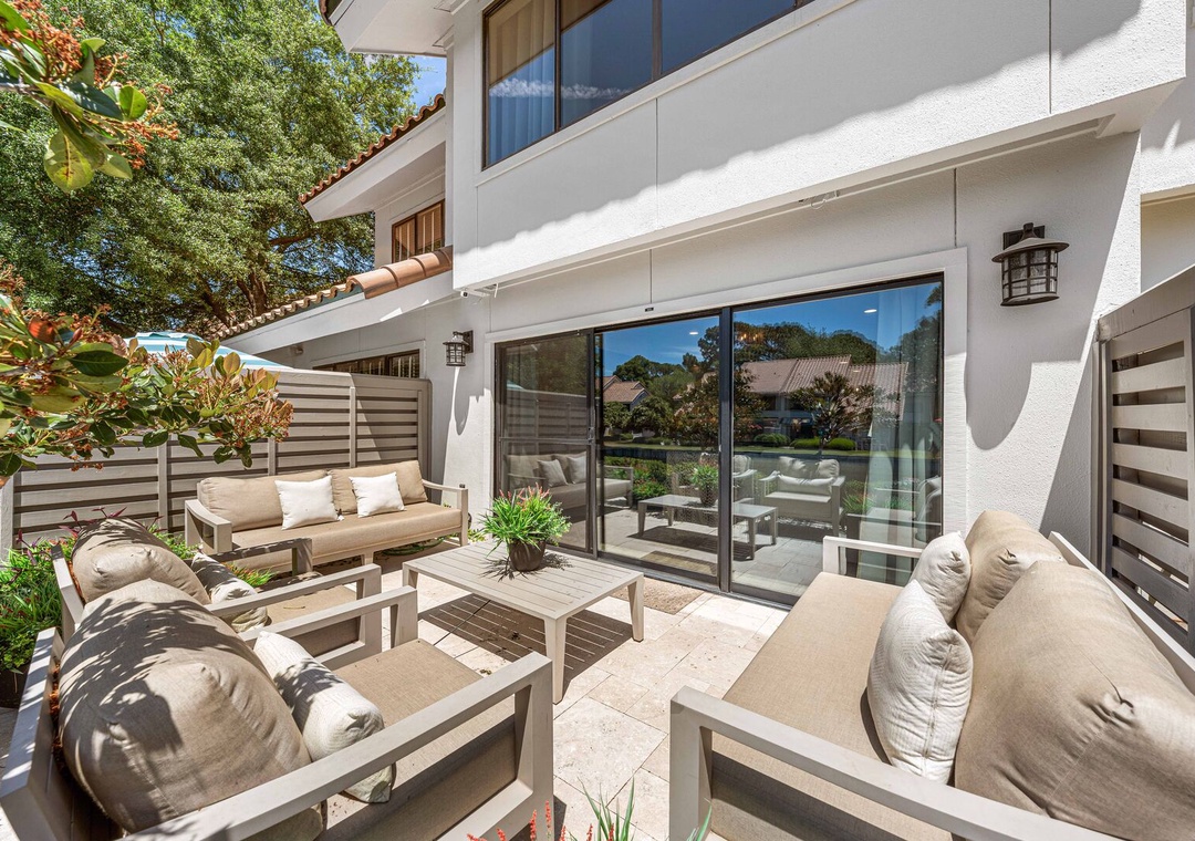 This patio features cozy outdoor sofas and a table.