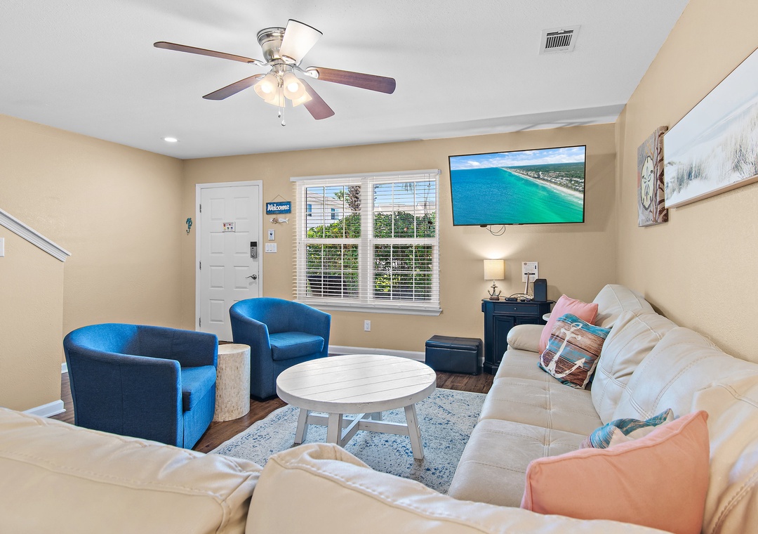 Kick back in this bright and welcoming living room featuring a large smart TV, cozy seating, and all the coastal vibes you need for the perfect vacation.