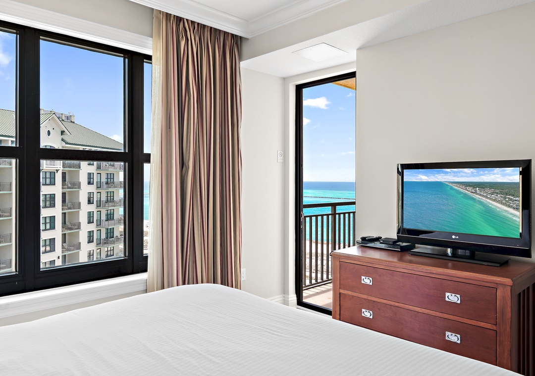 Guest bedroom features stunning water views and private balcony access.
