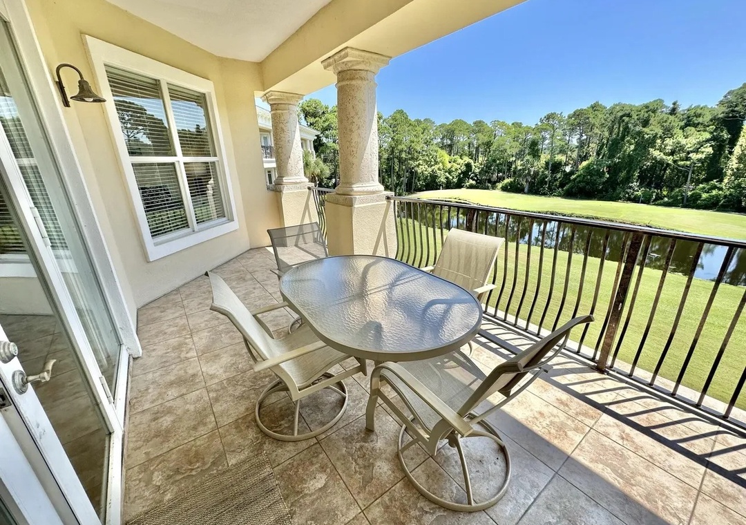 Enjoy peaceful mornings on the spacious covered balcony overlooking lush greenery and the water