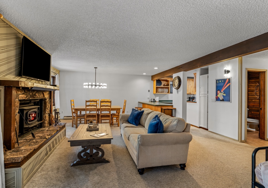 Relax in your spacious living area featuring a cozy fireplace, comfortable seating, and dining space where you'll create lasting memories.