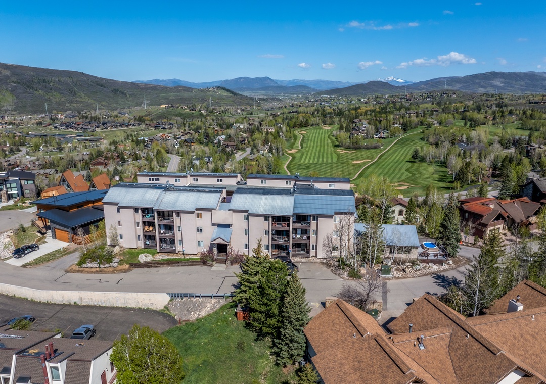This property sits in a scenic mountain community, with golf course greens, tree-lined streets, and expansive peaks defining the surrounding area.
