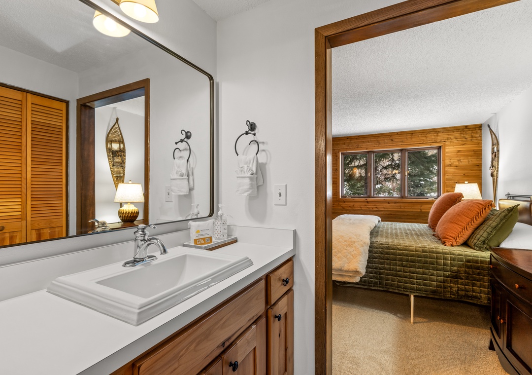 Step from your primary bathroom into the cozy bedroom, where warm wood tones and rich textiles create your perfect mountain retreat.