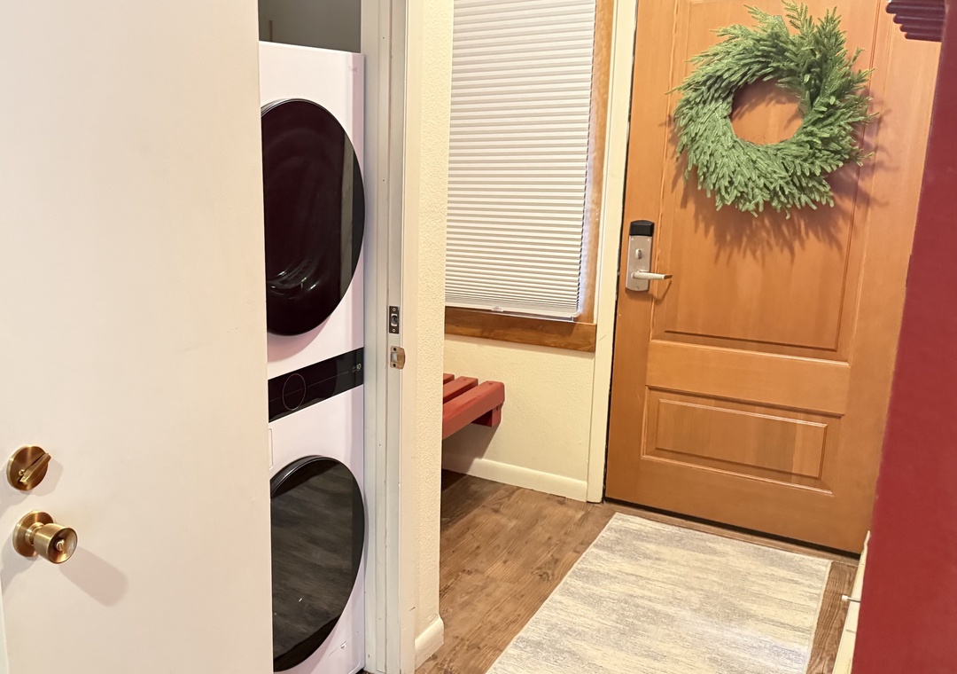 In-unit laundry with stacked washer and dryer.