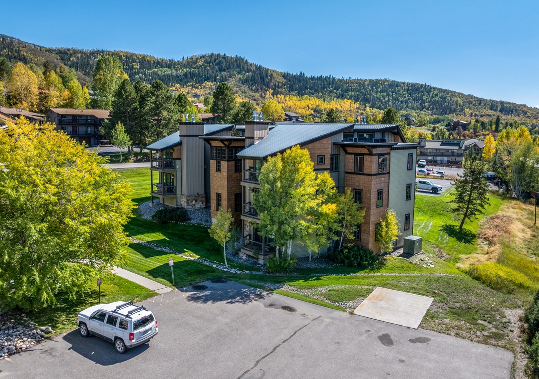 Modern mountain retreat nestled among aspens and evergreens, featuring expansive lawns, convenient parking, and a peaceful setting beneath forested peaks—ideal for exploring nearby trails.