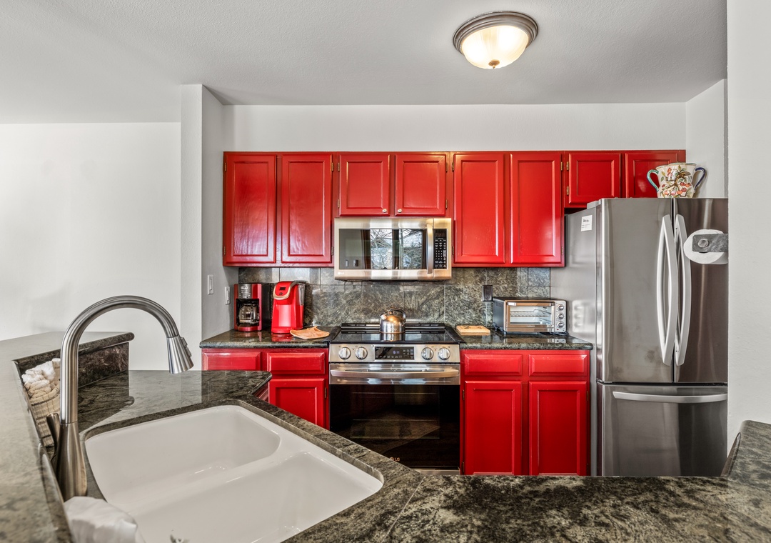 Your fully equipped kitchen features bold red cabinets and granite counters, perfect for preparing memorable meals during your stay.