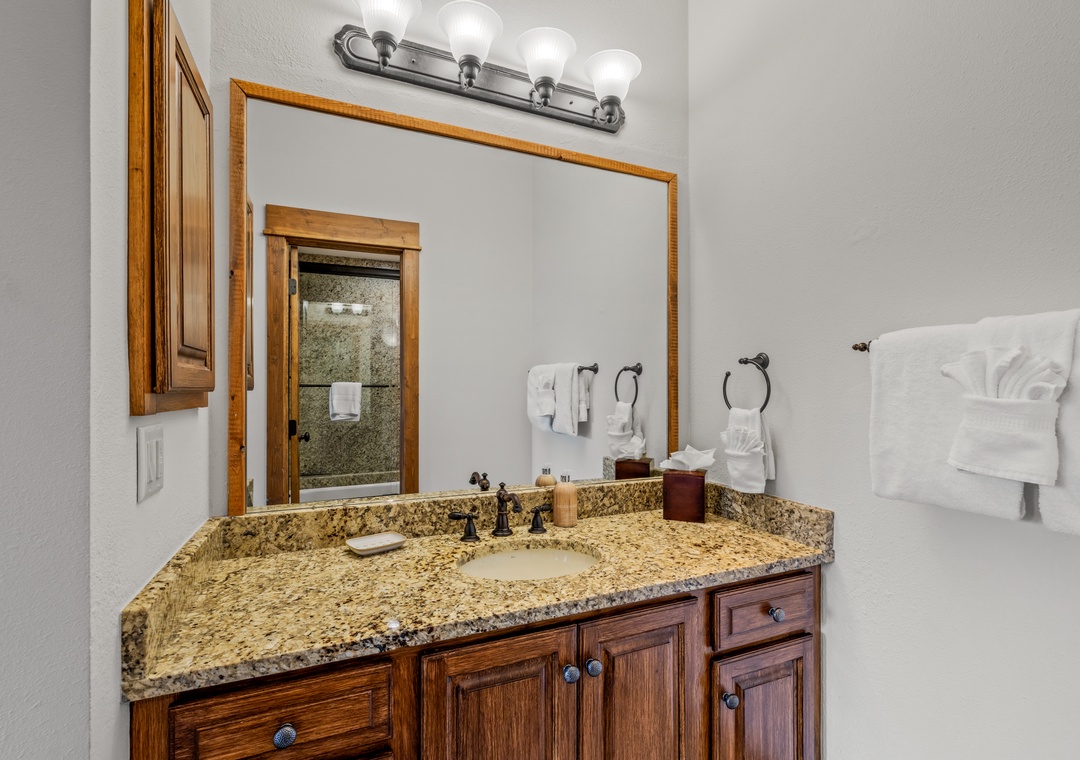 Indulge in your private bathroom featuring granite counters, warm wood finishes, and plush towels awaiting your arrival.