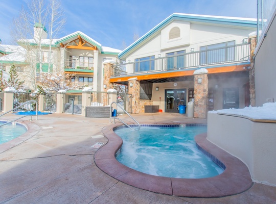 Outdoor hot tubs nestled in a courtyard setting with mountain surroundings, perfect for unwinding after a day of adventure.