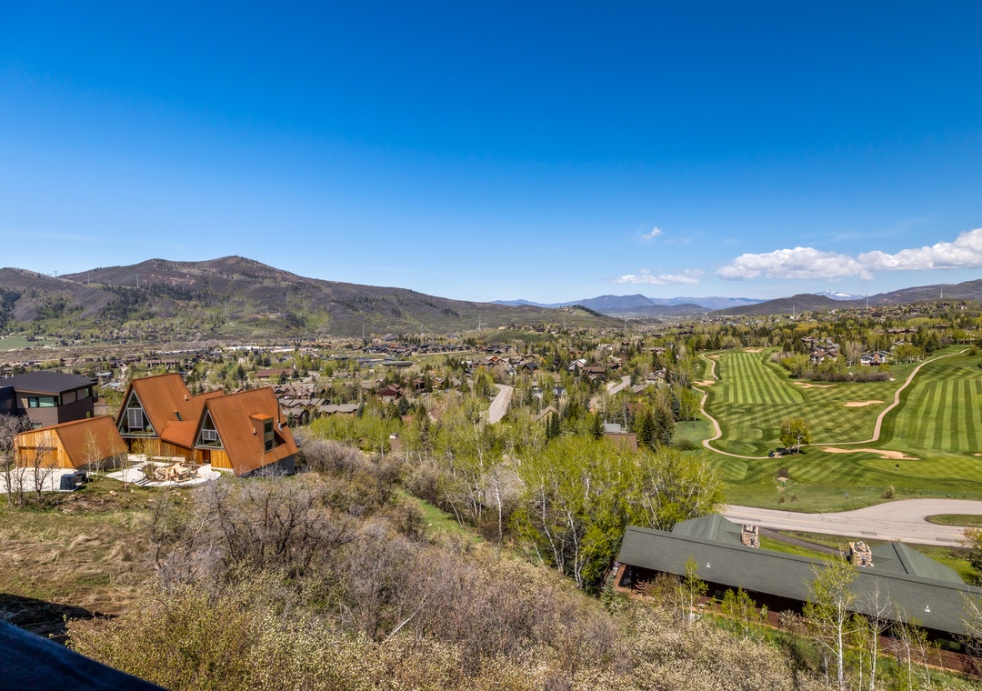 This aerial view captures the property's location in a scenic mountain setting, with a championship golf course and surrounding natural landscape defining the neighborhood.