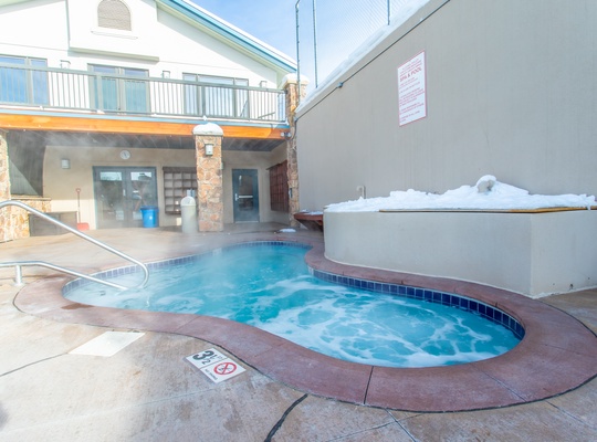 Soak your cares away in the bubbling outdoor hot tub, set in a cozy courtyard space perfect for unwinding after a day of adventure.