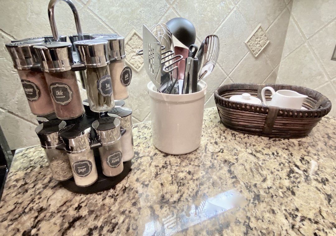 Your kitchen is stocked with gleaming utensils and a thoughtful spice rack, ready for you to whip up a meal just the way you like it.