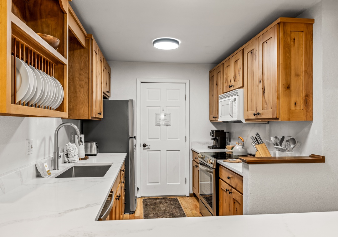 Your fully equipped kitchen features warm wood cabinetry, gleaming countertops, and everything you need to prepare your favorite meals—from morning coffee to a homemade feast.
