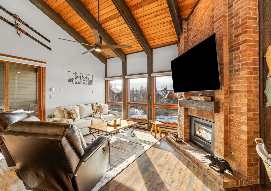 Cozy up by the warm brick fireplace while enjoying mountain views from your comfortable living room retreat.