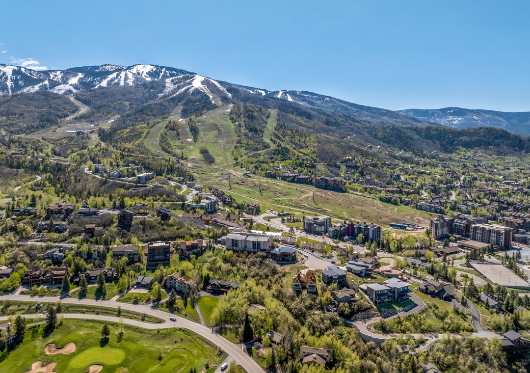 An aerial perspective showing the property's location in a mountain resort community, with ski slopes visible on the hillside in the background.
