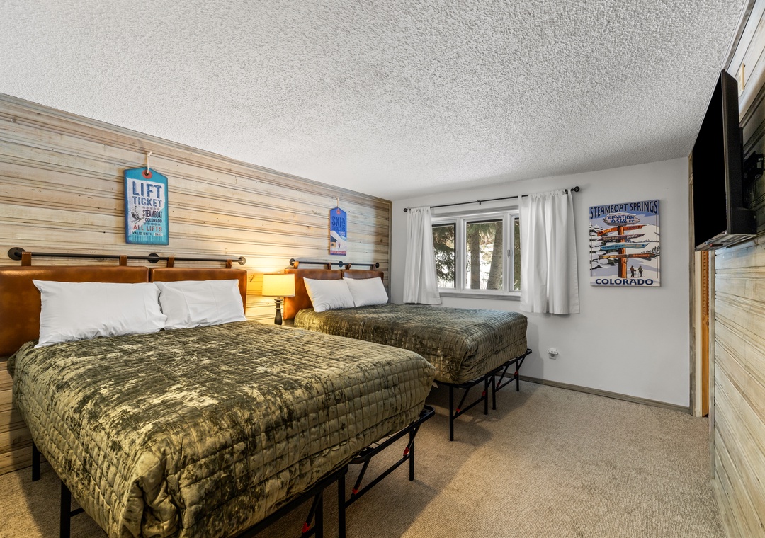 Relax in your cozy mountain-themed bedroom with two comfortable beds, warm wood accents, and ski lodge charm perfect for your Colorado getaway.