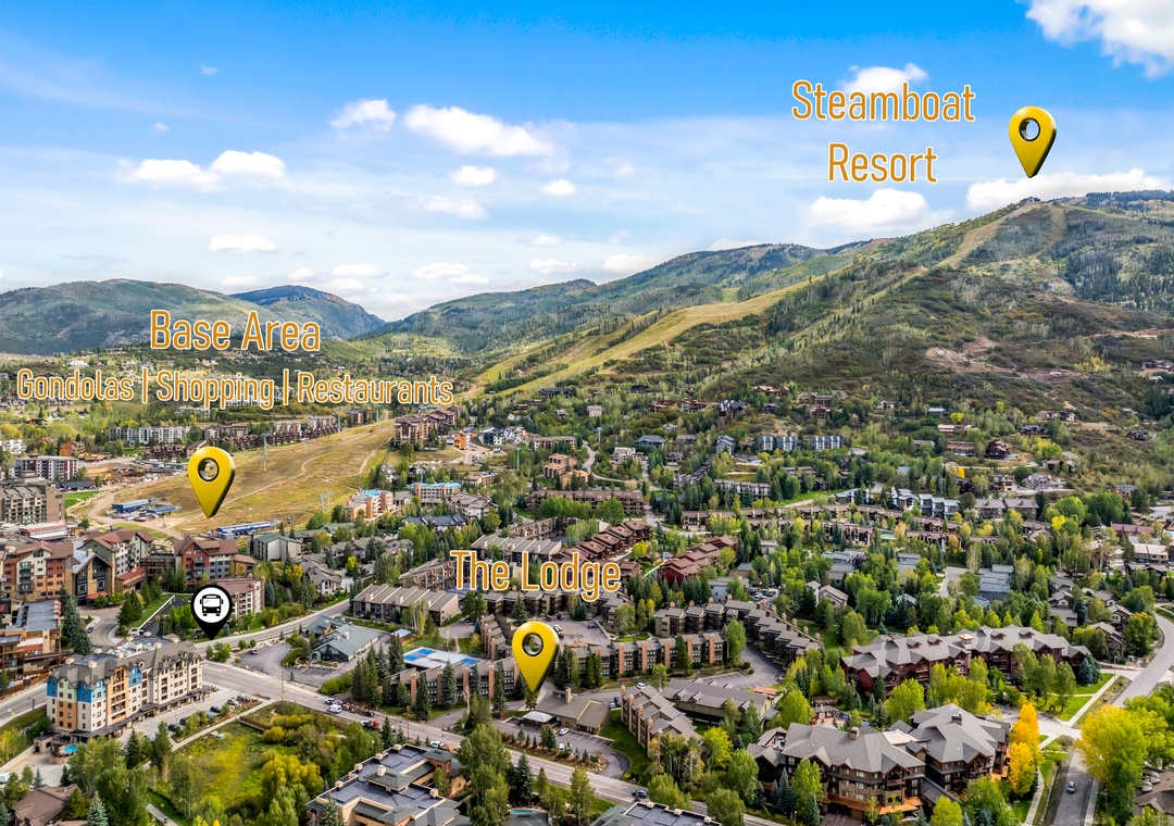 An aerial overview of the resort area, nestled among rolling mountains with easy access to base amenities, shops, and dining—all within a scenic alpine setting.