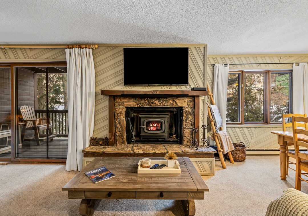 Cozy up by your crackling fireplace while watching TV in this warm living room with mountain views from your private balcony.