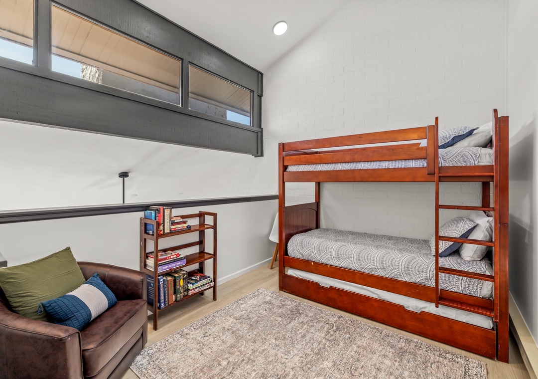 Non-conforming bedroom in the loft area featuring sturdy bunk beds with a trundle and a comfortable seating area.