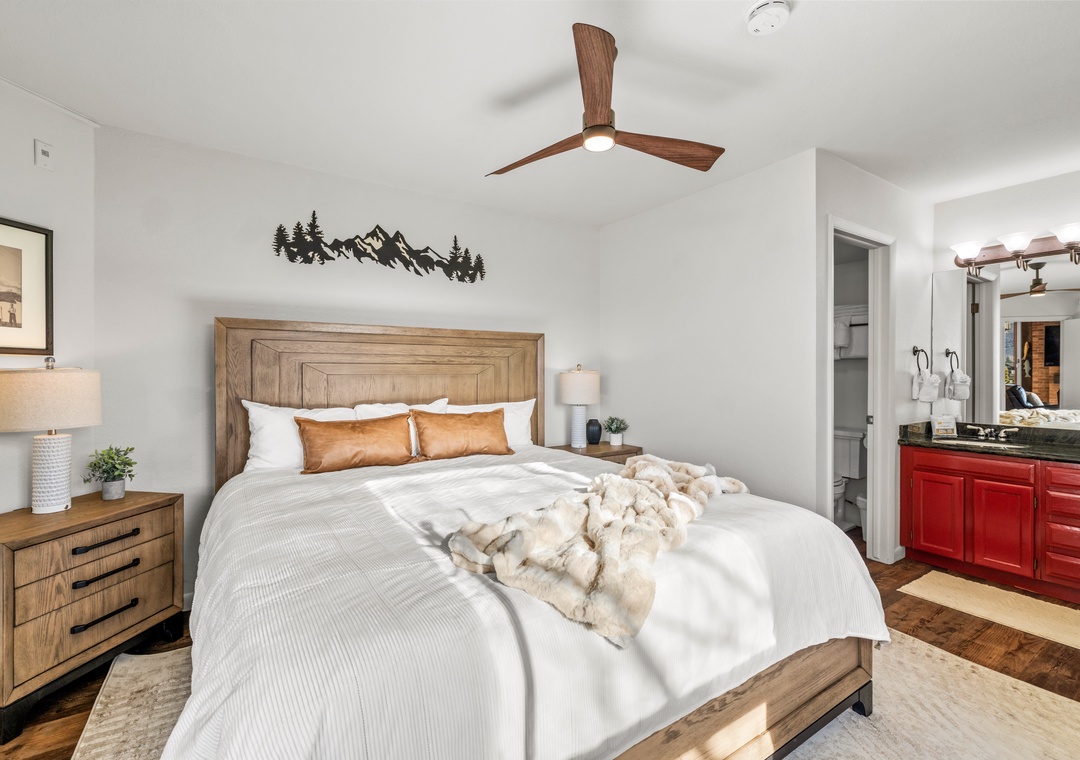 Unwind in your serene bedroom featuring a cozy wooden bed, soft linens, and mountain-inspired decor that creates the perfect retreat.