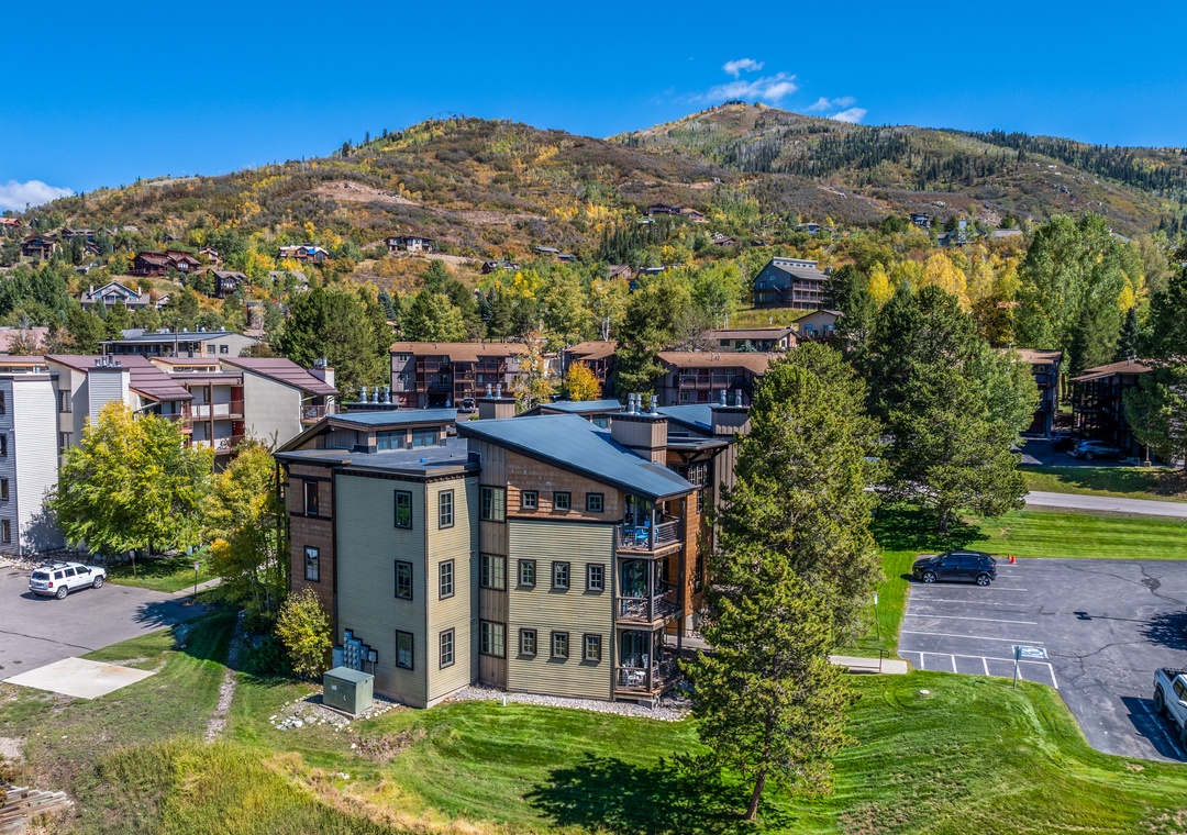 This mountain resort property sits in a scenic valley surrounded by rolling hills covered in autumn foliage and evergreens, with convenient parking and easy access to nearby outdoor activities.