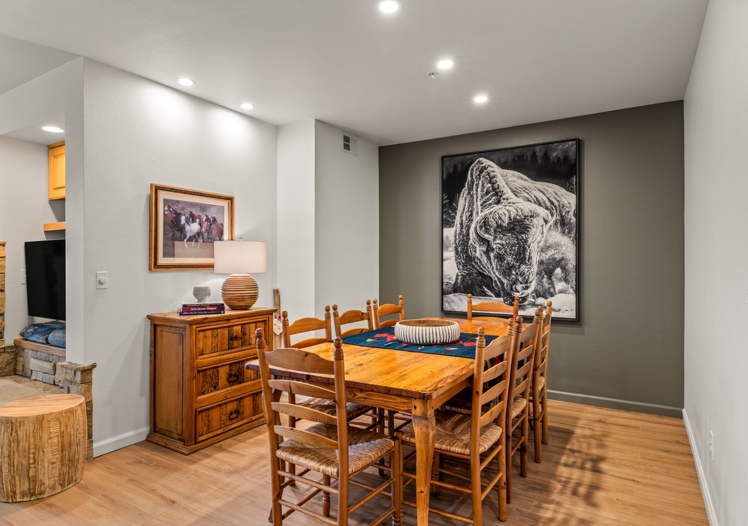 Gather around your rustic dining table for memorable meals, surrounded by mountain-inspired artwork and warm wood furnishings that create the perfect alpine atmosphere.