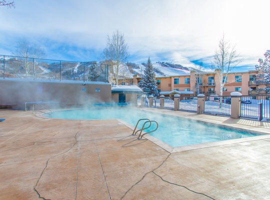 Soak in the heated outdoor pool and jacuzzi while steam rises into the crisp mountain air, with snowy peaks framing your winter escape.