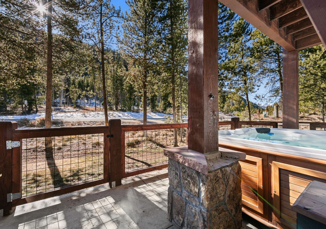 Soak in your private hot tub while surrounded by towering pines and winter scenery on this peaceful covered deck.