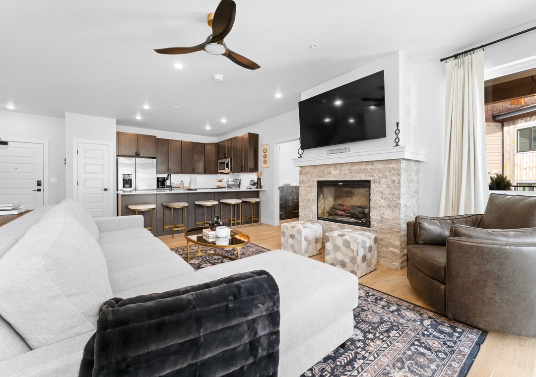 Relax in your stylish open-concept living space with cozy fireplace, modern kitchen, and comfortable seating perfect for gathering.