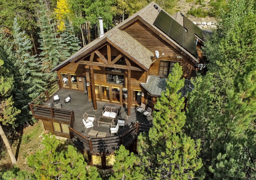 Stunning mountain cabin nestled among towering pines with spacious deck and forest views.