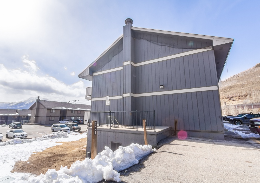 Modern mountain property featuring contemporary architecture with convenient parking and stunning alpine surroundings in a peaceful winter setting.